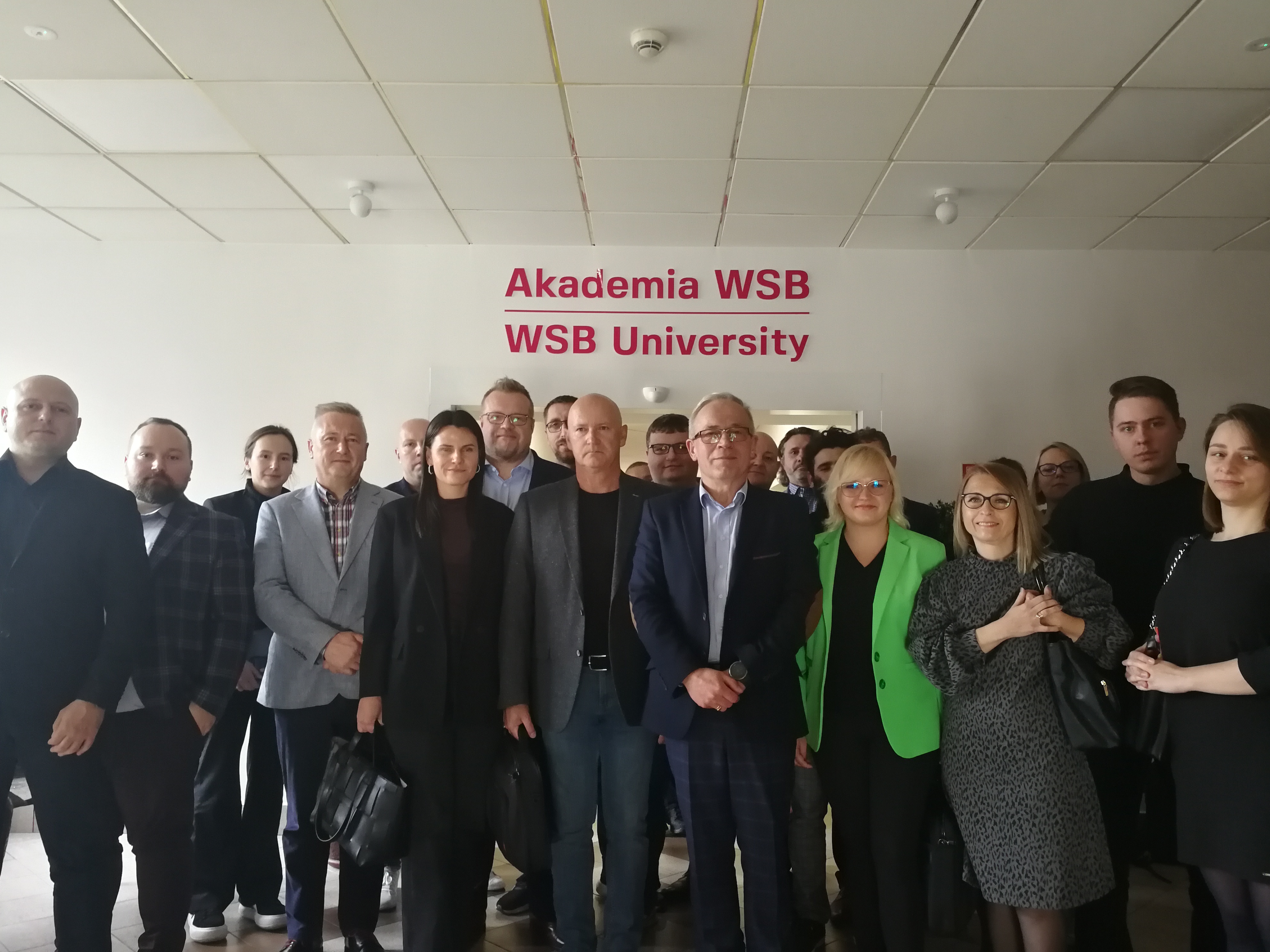 Grupa ludzi pozująca do zdjęcia w Akademii WSB.